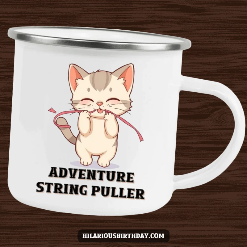 Funny mischievous kitten playfully tugging on a streamer on a camping mug, for fun playful outdoor adventures.