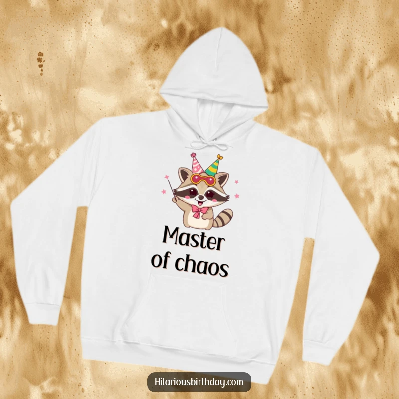 Funny delighted raccoon character wearing a party mask and juggling party hats, featured on a warm hoodie.