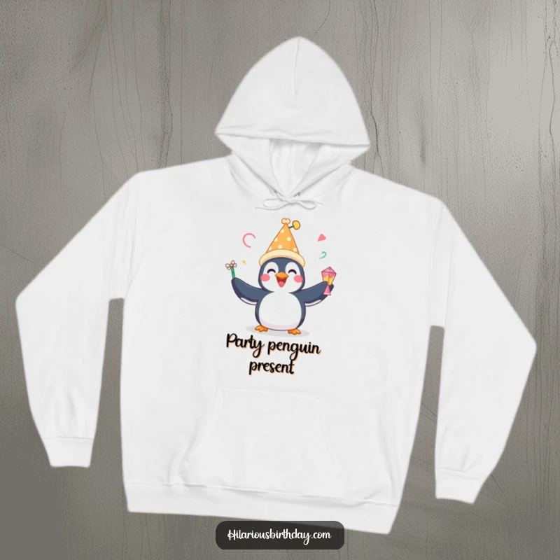 Funny hoodie with a happy penguin in a festive hat, gleefully juggling party favors, designed for ultimate cozy fun.