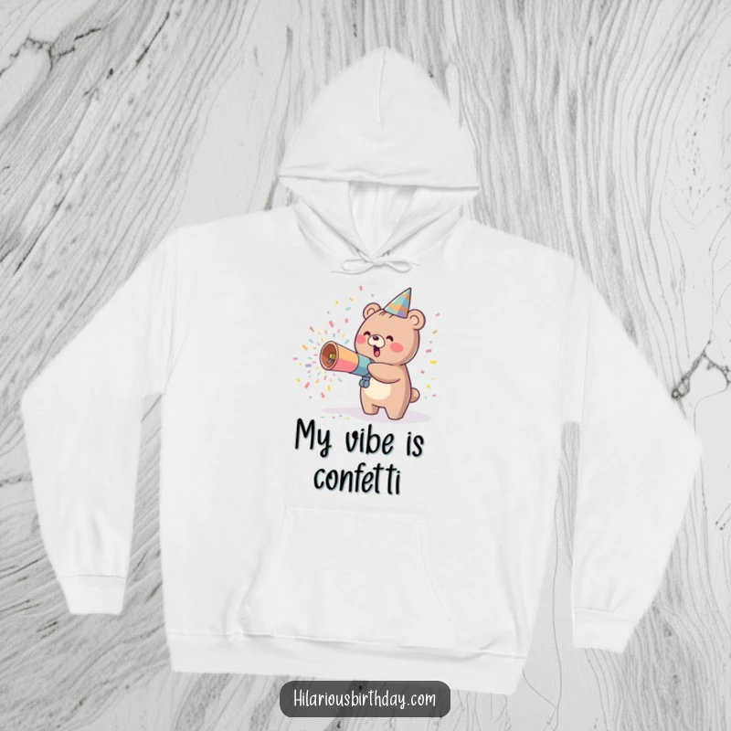 Funny kawaii bear character in a cozy hoodie, joyfully launching confetti from a party cannon, a delightful wearable celebration.